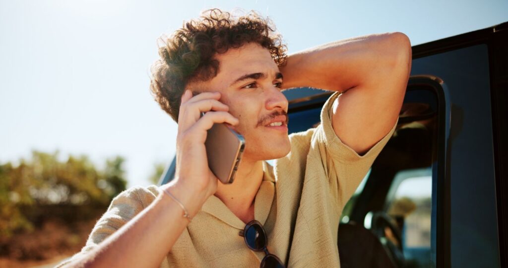 Driver on the phone arranging repairs after a car accident